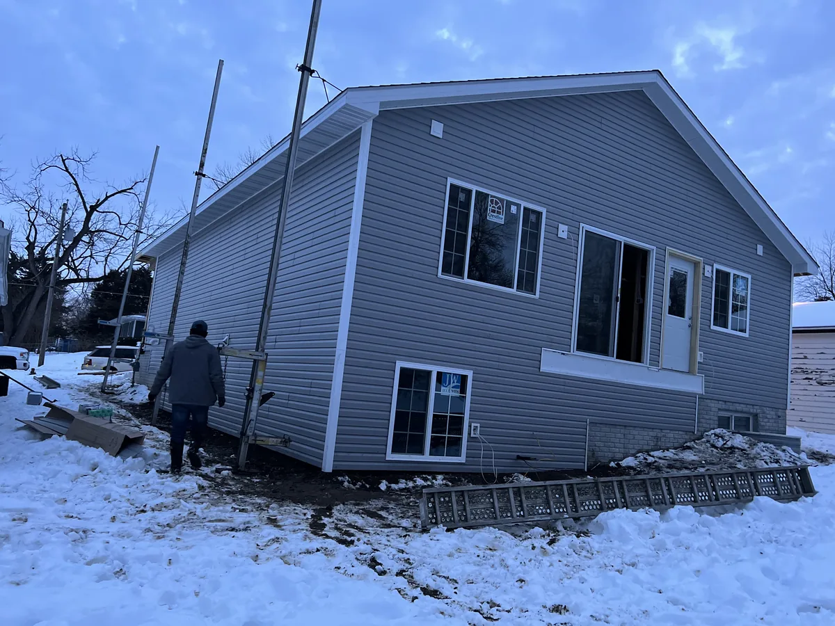 Light blue vinyl siding installed on a raised ranch home