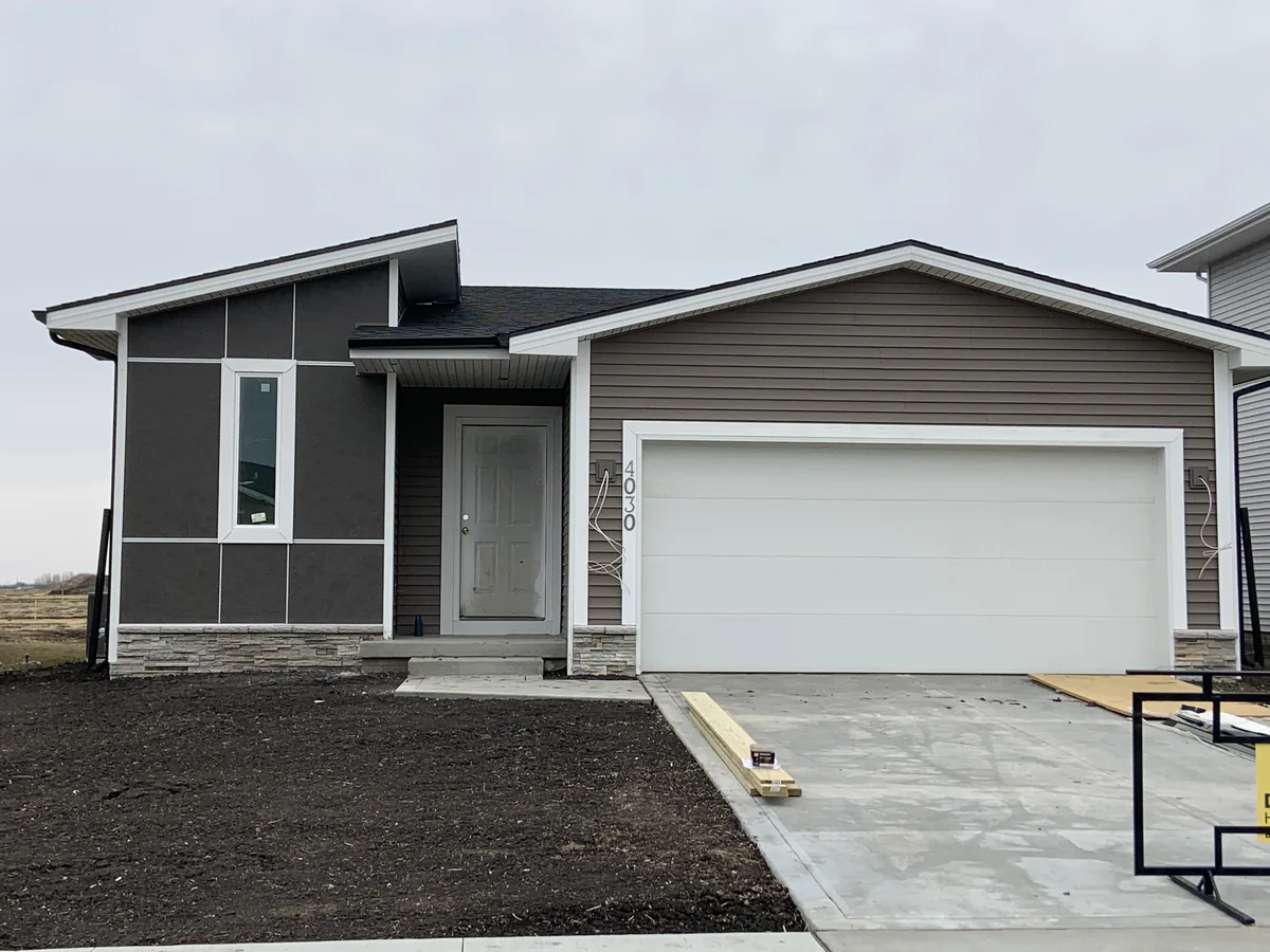 Tan and gray siding on a ranch home with screened porch